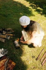 l'artiste mapie des vignes accroupie dans l'herbe et déroulant tous les paquets de tissu et plantes, après 3 semaines d'attente.